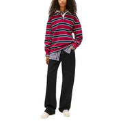 A maroon and navy blue striped long-sleeved polo shirt with a white collar paired with Tommy Hilfiger women’s black organic cotton jeans