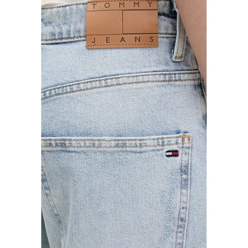 Back side of tommy hilfiger women’s light blue ripped jeans in light-wash denim with tan leather label and flag logo