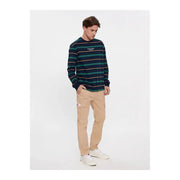 Tommy Jeans men beige cotton elastane trousers paired with a navy and teal striped long-sleeve crewneck sweatshirt