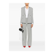 Ensemble gris pour femme, composé d'un blazer croisé en laine mélangée avec poignets blancs et d'un pantalon assorti, porté sur une chemise blanche.