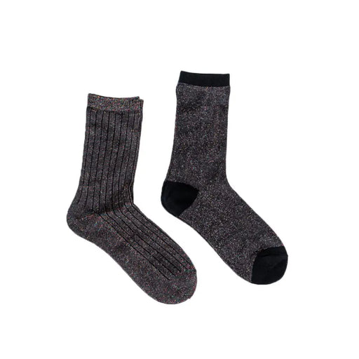 Two gray socks alongside a coffee cup with lid on a stylish display