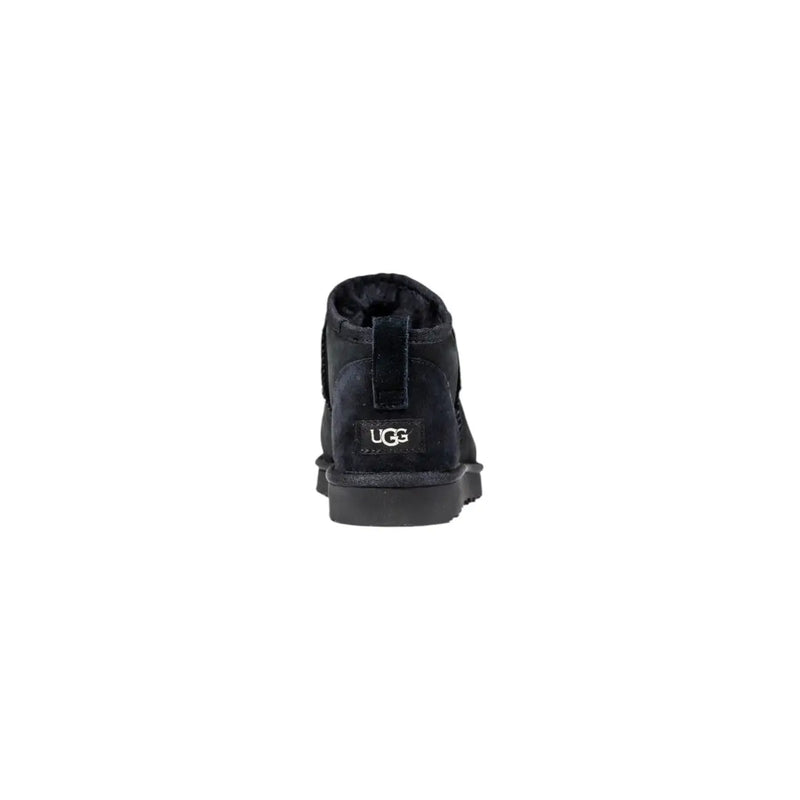 Bottes Ugg pour homme en cuir noir, modèle classique à enfiler, avec intérieur moelleux et extérieur en daim visible à l'arrière.