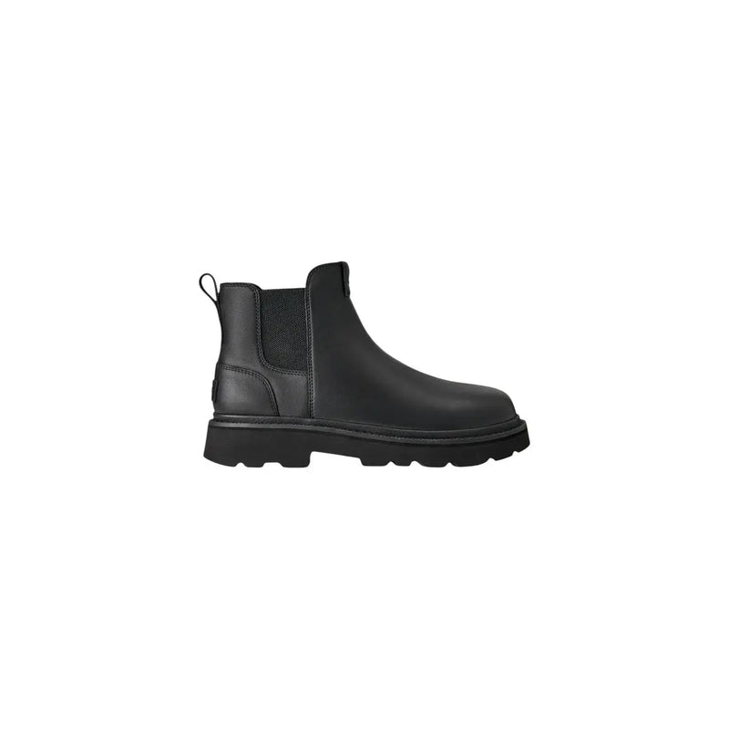Bottes Chelsea Ugg pour homme en cuir noir, style classique, avec empiècements élastiques latéraux et semelle épaisse en caoutchouc.