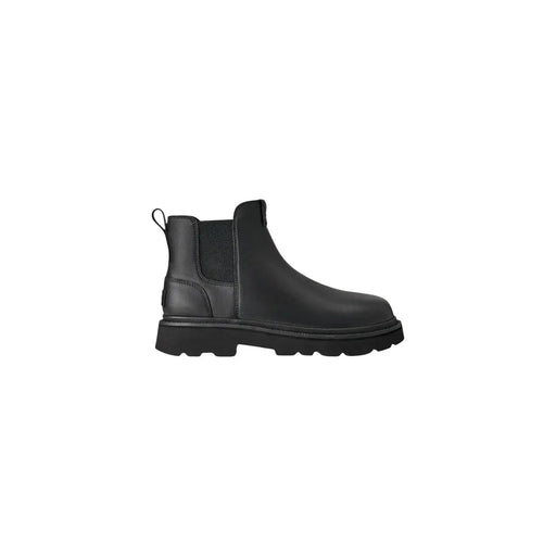 Bottes Chelsea Ugg pour homme en cuir noir, style classique, avec empiècements élastiques latéraux et semelle épaisse en caoutchouc.