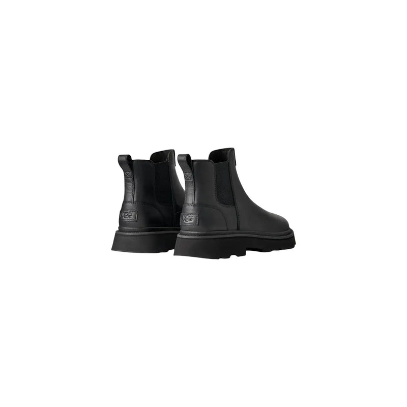 Bottes Chelsea Ugg pour homme en cuir noir, style classique, design minimaliste et élégant, semelles épaisses.