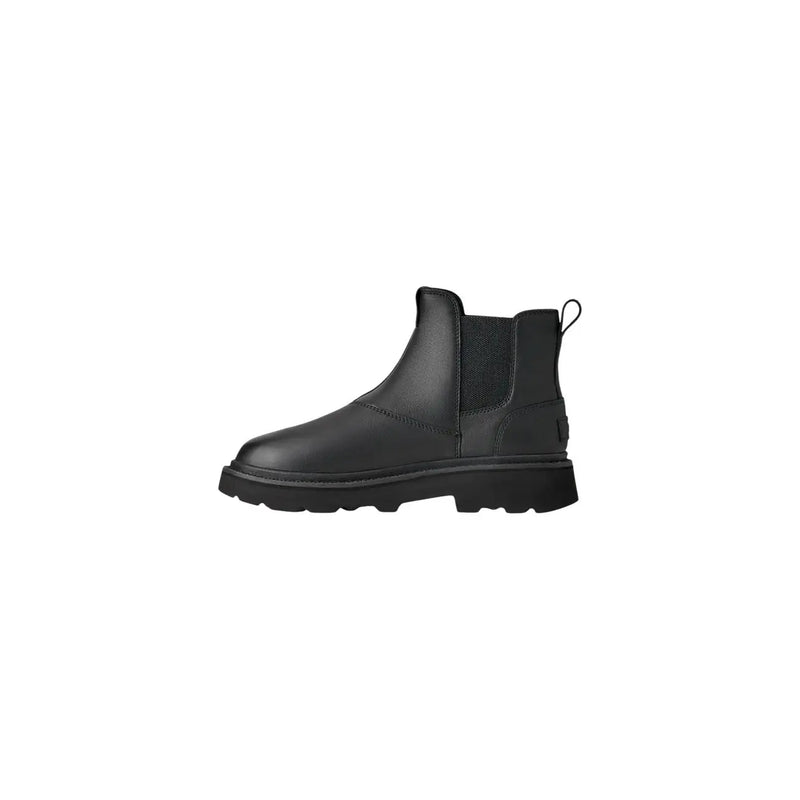 Bottines Chelsea Ugg pour homme en cuir noir, dotées d'empiècements élastiques latéraux et d'une semelle épaisse en caoutchouc, dans un style classique.