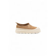 Pantoufles Ugg pour homme en daim beige, à enfiler, avec semelle épaisse crème et logo Ugg, idéales pour l'hiver.