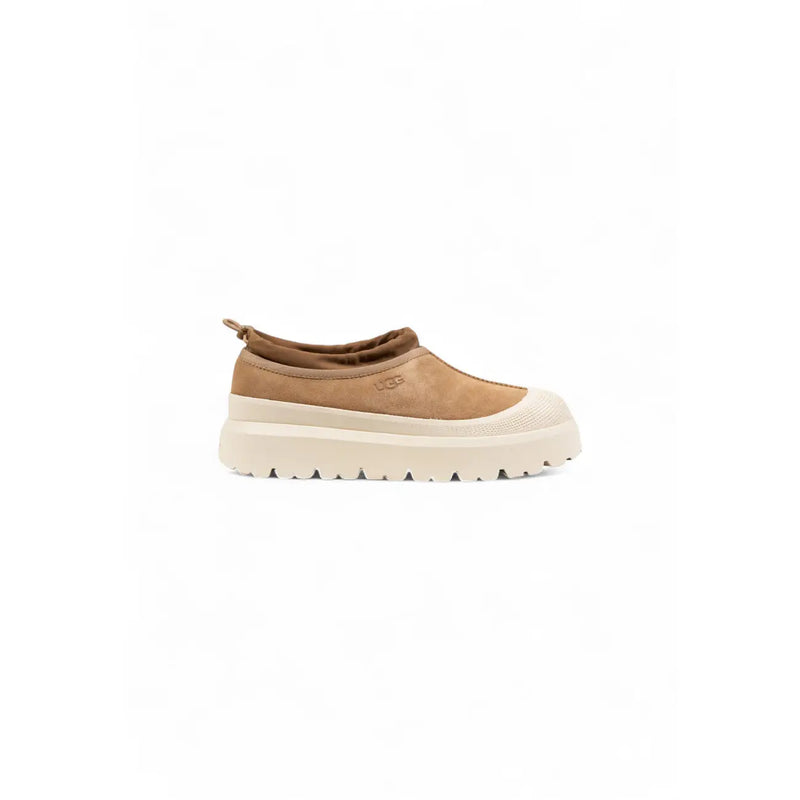 Pantoufles Ugg pour homme en daim beige, à enfiler, avec semelle épaisse crème et logo Ugg, idéales pour l'hiver.