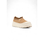 Pantoufles Ugg pour homme en daim beige, modèle slip-on en daim camel, bout en mesh crème et semelle plateforme blanche épaisse.