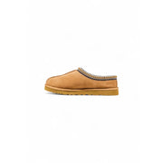 Ugg women beige suede round toe slippers with tan suede slip-on mule design and decorative woven trim for fall winter