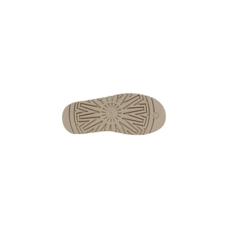 Beige rubber sole with geometric tread pattern and ugg logo embossed on ugg women leather platform slippers spring