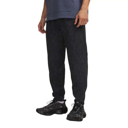 Under Armour Pantalon de jogging en molleton pour homme, en mélange de coton noir, avec un tissu texturé doux et des détails de coutures latérales discrets.