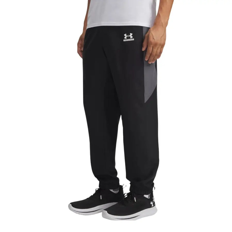 Under Armour Pantalon de survêtement noir pour homme, avec empiècement latéral gris et logo blanc à la taille, idéal pour le sport.