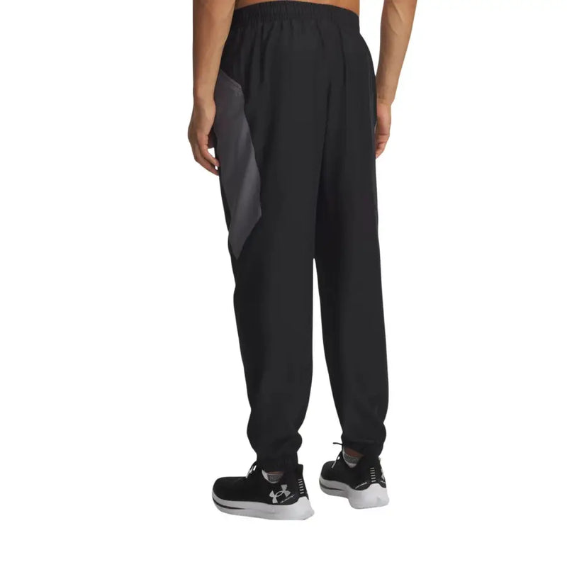 Under Armour Pantalon de jogging noir pour homme, style athlétique, avec empiècement latéral gris, taille élastiquée et cordon de serrage.
