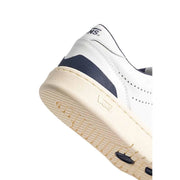 Baskets basses blanches Vans Court pour homme, en cuir avec empiècement en mesh bleu marine et semelle en caoutchouc crème.