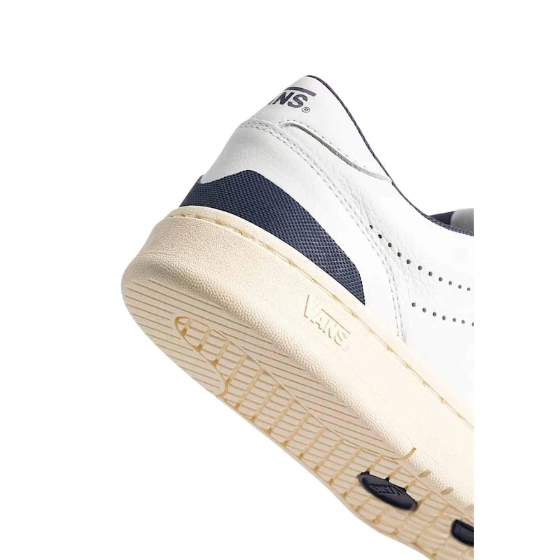 Baskets basses blanches Vans Court pour homme, en cuir avec empiècement en mesh bleu marine et semelle en caoutchouc crème.