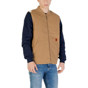 Gilet sans manches zippé beige en mélange de coton Vans pour homme, avec fermeture éclair intégrée, manches longues bleu marine et écusson orange sur la poitrine.