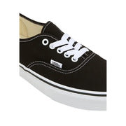 Baskets Vans pour homme, en tissu noir à lacets blancs, semelle en caoutchouc et surpiqûres blanches contrastantes.