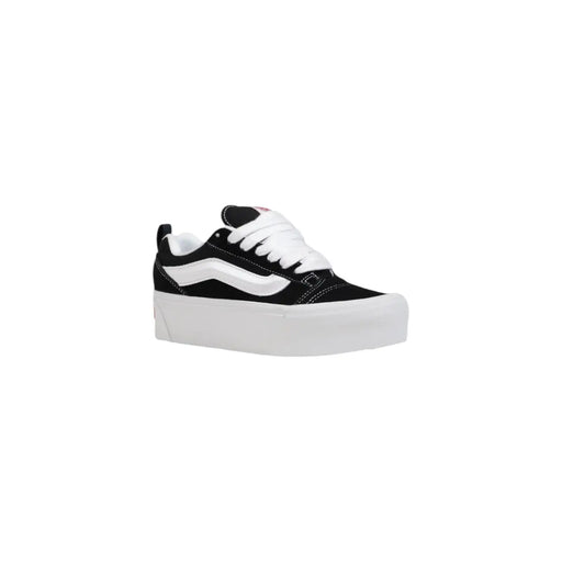 Baskets Vans noires pour femmes en cuir, avec lacets blancs, bande latérale emblématique et semelles épaisses en caoutchouc blanc.