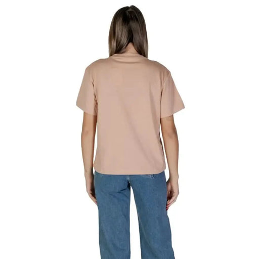 Back view of a model in a Calvin Klein Jeans pink cotton t-shirt and blue pants