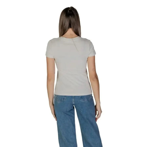 Back view of a model in a light gray t-shirt and blue jeans wearing Calvin Klein Jeans