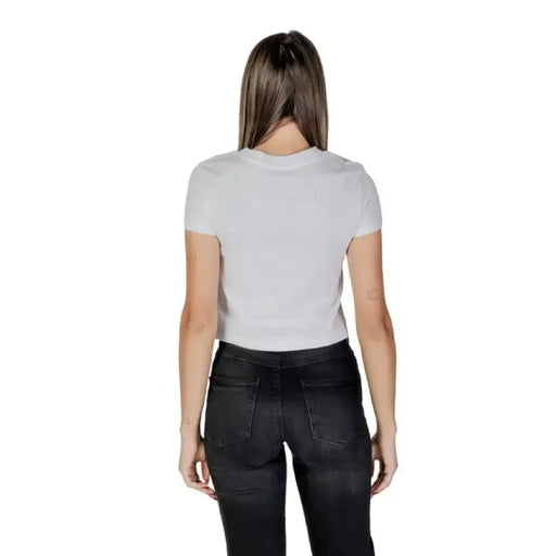 Back view of a person in Calvin Klein Jeans Women’s White Print Cotton T-shirt and dark jeans