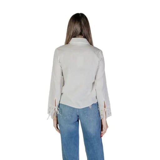 Back view of Jacqueline De Yong Women’s white turtleneck shirt with bell sleeves and jeans