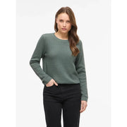 Pull long en maille de coton noir à col rond pour femme Vila, associé à un pull en maille texturée vert olive à poignets côtelés.