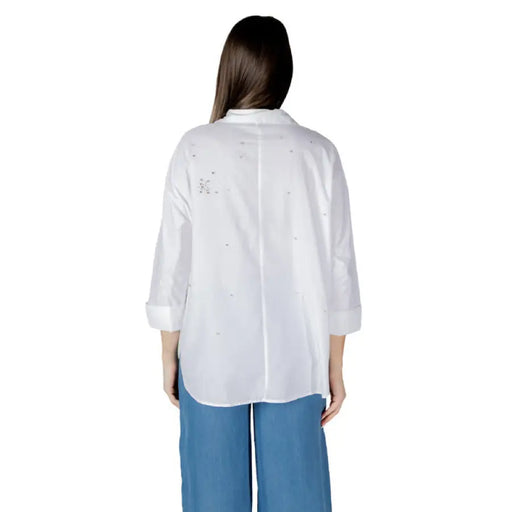 Womens white embellished button-down shirt paired with blue pants for a stylish look
