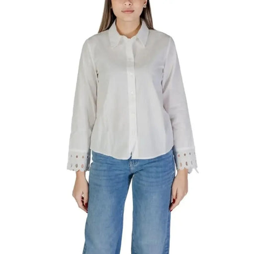White button-up blouse with decorative cuffs paired with blue jeans by Jacqueline De Yong