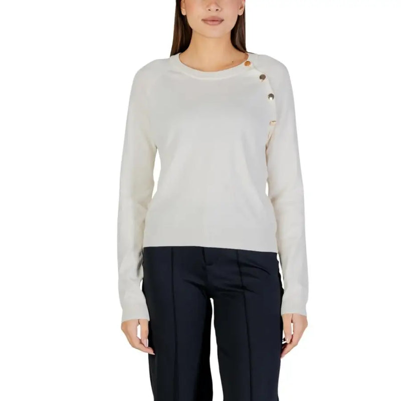 Cream-colored long sleeve round neck knit top for women with subtle textured knit and decorative shoulder buttons