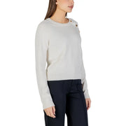 Cream-colored long sleeve round neck knit top for women with gold toned buttons on the shoulder