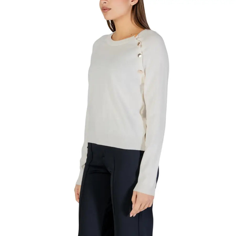 Cream-colored long sleeve round neck knit top for women with subtle ribbed texture and decorative side seam buttons
