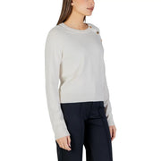 Cream-colored long sleeve round neck knit top for women with gold toned buttons on the shoulder