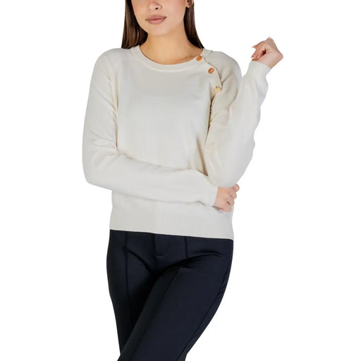 White long sleeve round neck knit top for women in cream color with wooden buttons along the shoulder seam