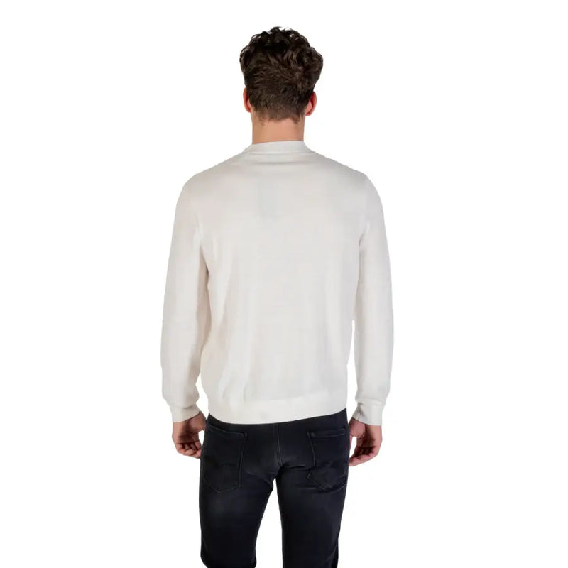 A white long sleeved crewneck sweater with a smooth cream colored knit texture suitable for casual wear