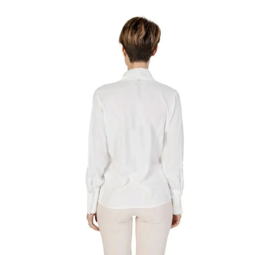 Rinascimento Women’s White V-Neck Long Blouse with light-colored pants displayed elegantly