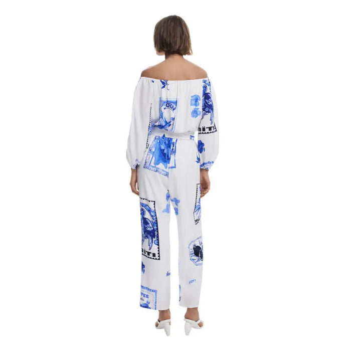 White off-the-shoulder jumpsuit with blue floral tile print, stylish and elegant attire