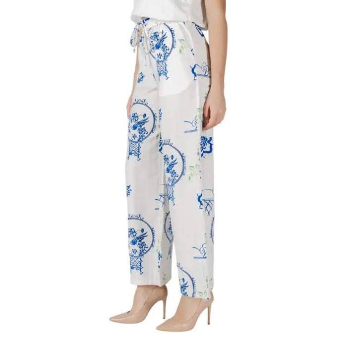 White wide leg pants with blue and yellow patterns featuring a drawstring design