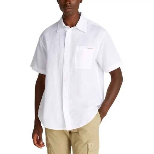 White short-sleeved button-down shirt displayed with Khaki Pants in the product image