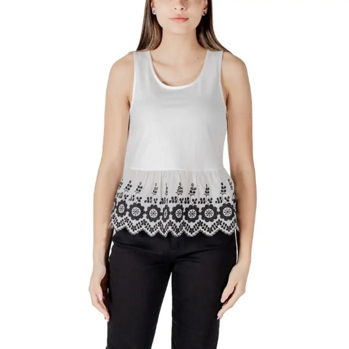 White sleeveless top featuring black floral trim for elegant summer wear