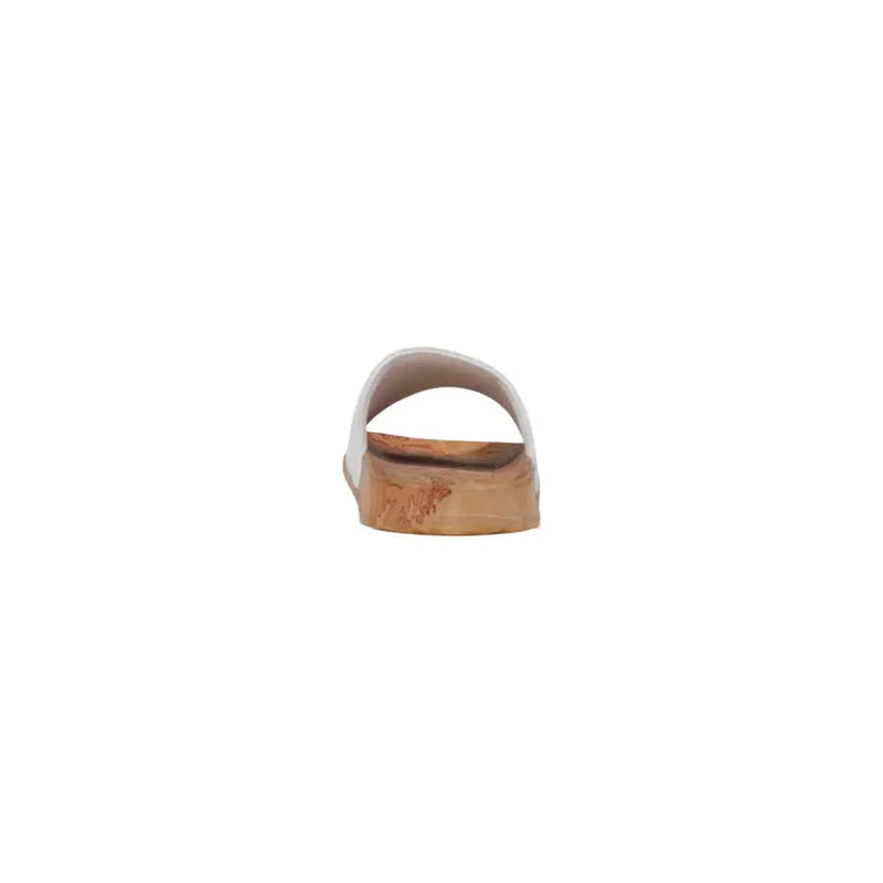 White slide sandal with cork sole and subtle embossed logo on the heel shown from the back side