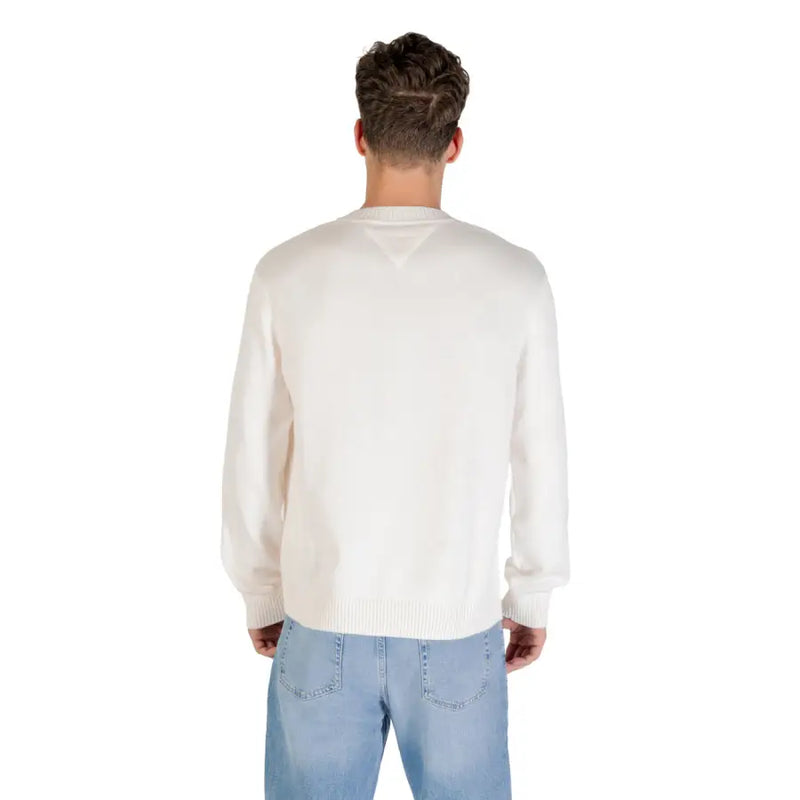Cream-colored long-sleeved knit sweater with ribbed crew neckline and cuffs featuring a red logo