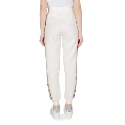 White Guess Active Women’s Cotton Trousers featuring decorative side stripes viewed from behind