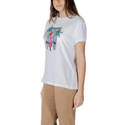 White cotton t-shirt featuring a colorful embroidered graphic of a woman in a pink dress with palm trees