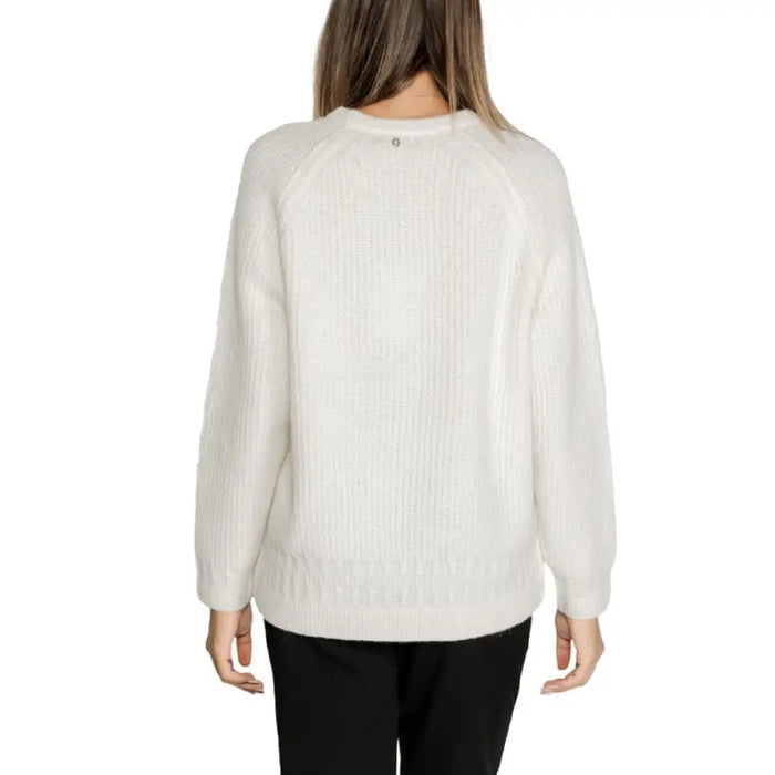 White textured knit sweater paired with black pants for a stylish, comfortable look