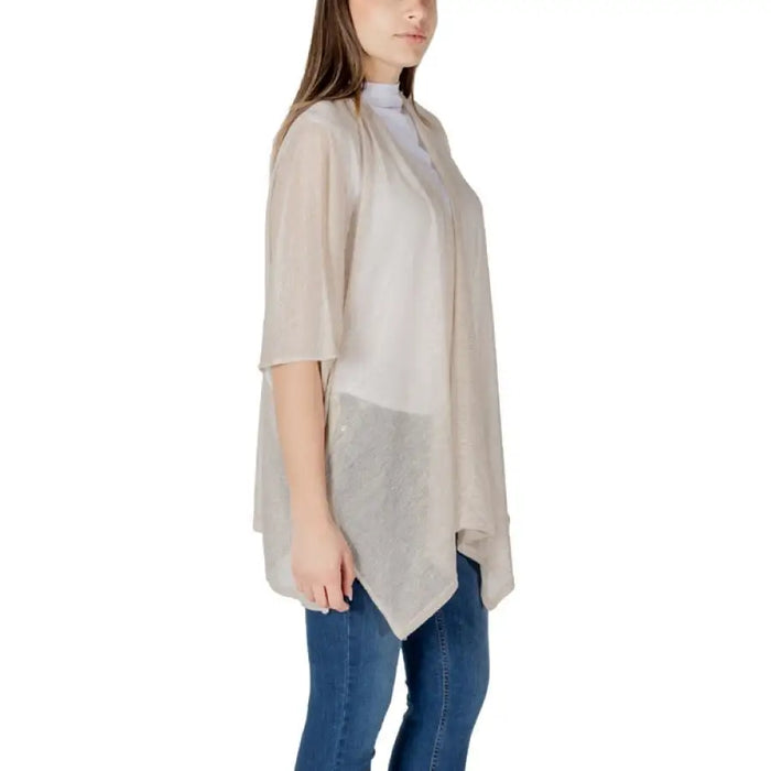 Woman wearing a beige cardigan and blue jeans in the Women’s Beige Cardigans and Poncho Collection