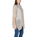 Woman wearing a beige cardigan and blue jeans in the Women’s Beige Cardigans and Poncho Collection
