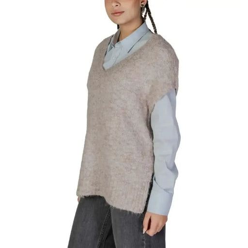 Woman modeling Vero Moda Women’s Beige Low-Cut V-Neck Sweater with a knit vest