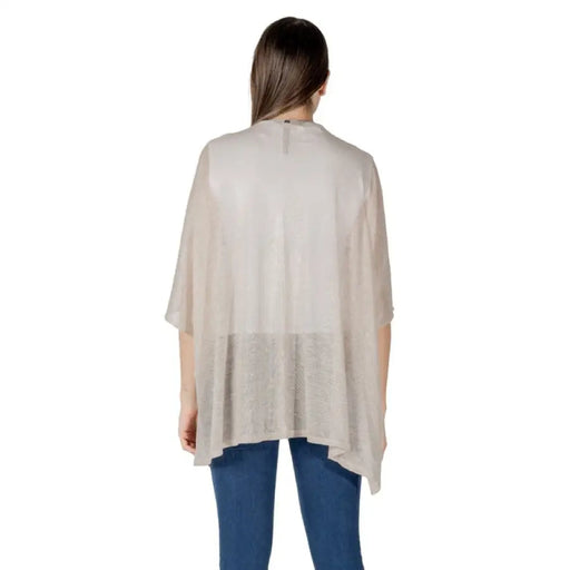 Woman wearing a beige poncho from the Women’s Beige Cardigans and Poncho Collection